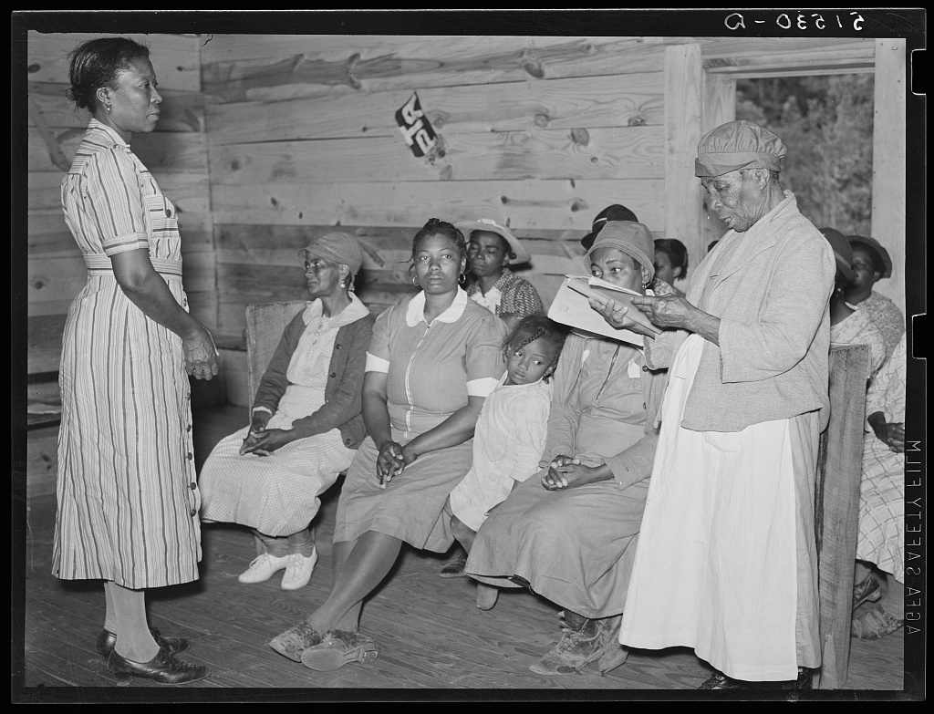 Juanita Coleman listening to one of her pupils read in her adult class